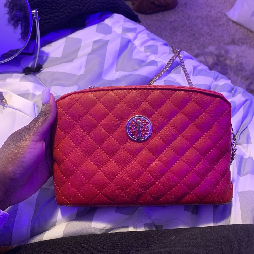 A cute red crossbody purse. worn a few times. very reliable. hold a lot of stuff